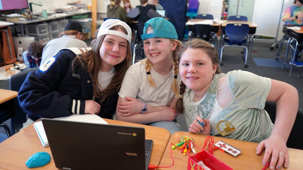 students smiling with laptop and electronics