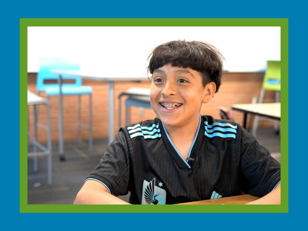 Student sitting in desk smiling